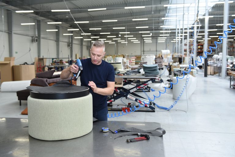 Polaszek Meble Mężczyzna używający zszywacza na kawałku Polaszka mebli w warunkach warsztatowych. Chojnice